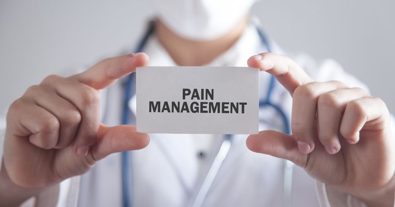 pain management card being held by a doctor